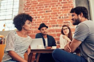 Portrait of young workers sitting at a cafe table and talking.