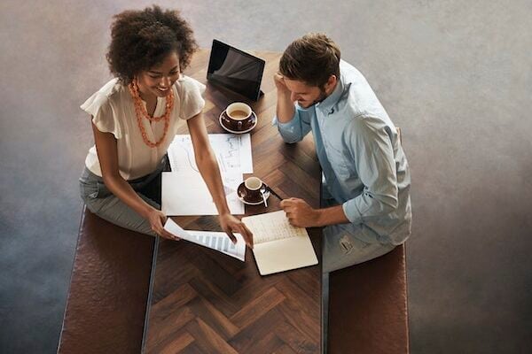Two people discussing work at a desk