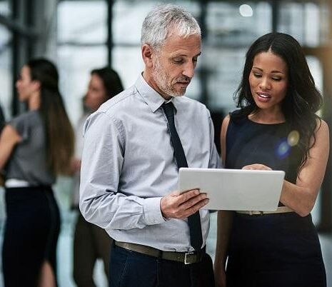 Shot of two professional coworkers using a digital tablet together at work