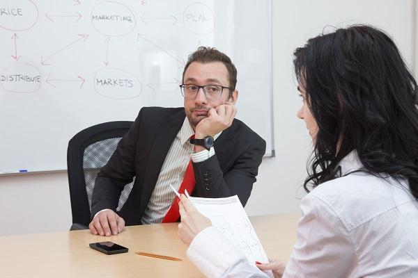 A man and a woman in an interview after making mistakes in the job search.