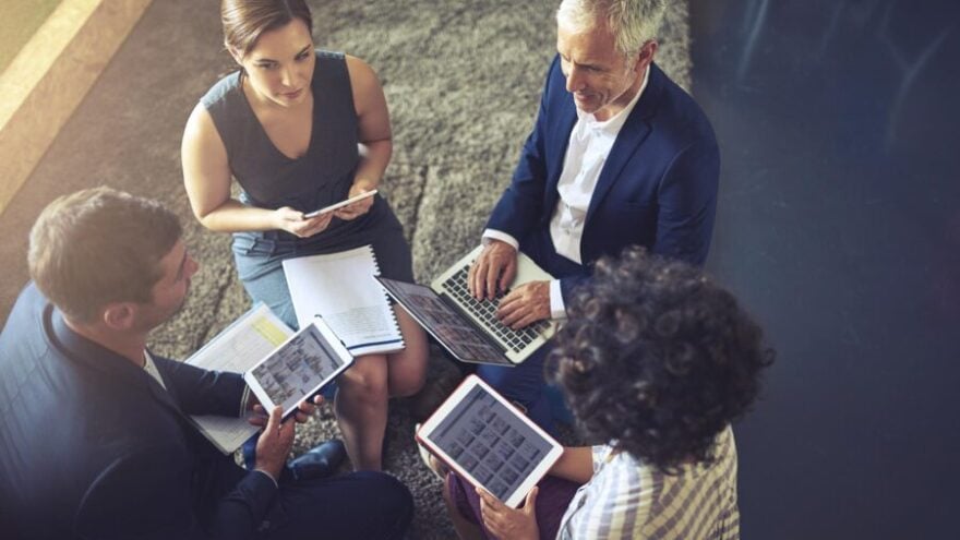 High angle shot of a group of businesspeople using their digital tablets