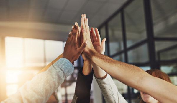 Shot of a group of colleagues giving each other a high five