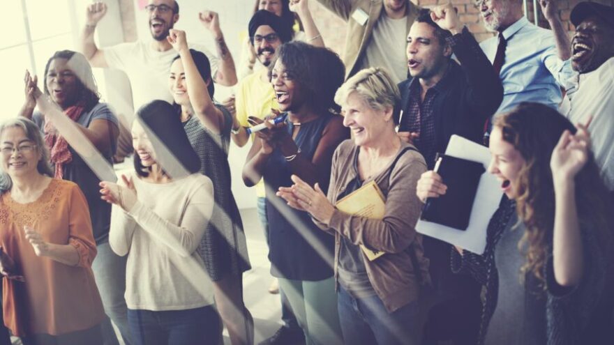 Group of people smiling and clapping at work
