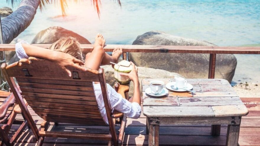 A woman laying on a deckchair on a tropical island, one of Brown + Hudson's insider travel tips for private PAs.