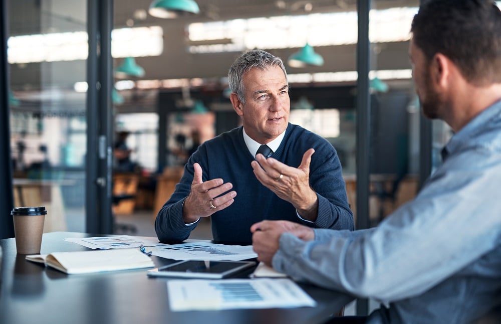 Two business people talking in an office meeting room