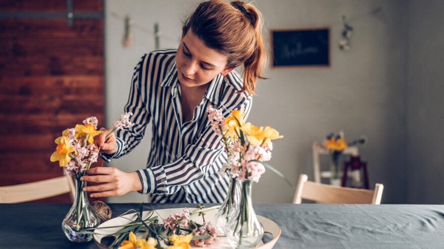 Private household staff member and housekeeper arranges flowers