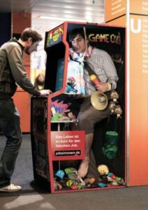 A photo of a man standing up playing an arcade game.