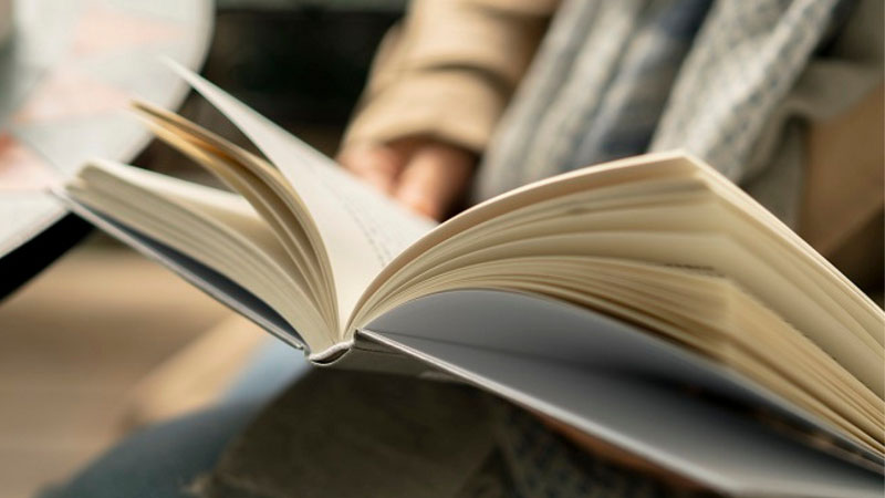Reading book while drinking coffee