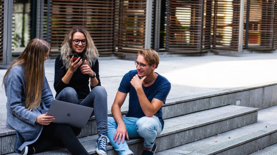 A photo of three employees collaborating in an outside meeting