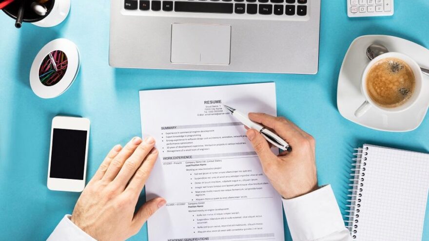 Businessman Reading Resume On Office Desk