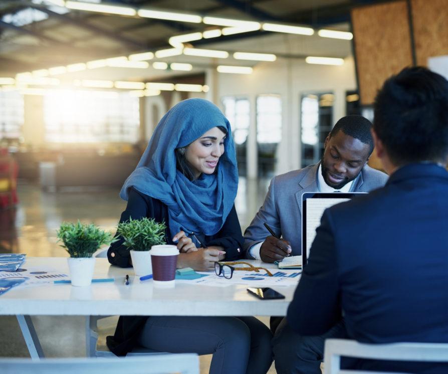 Three people sitting in an office