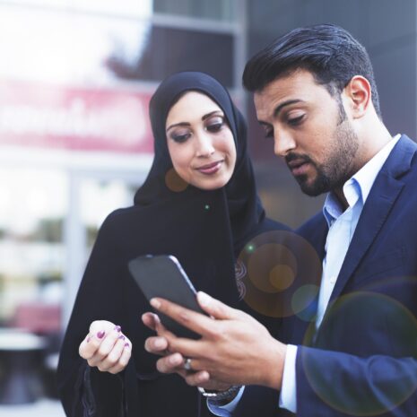 Two emirati professionals looking at a tablet