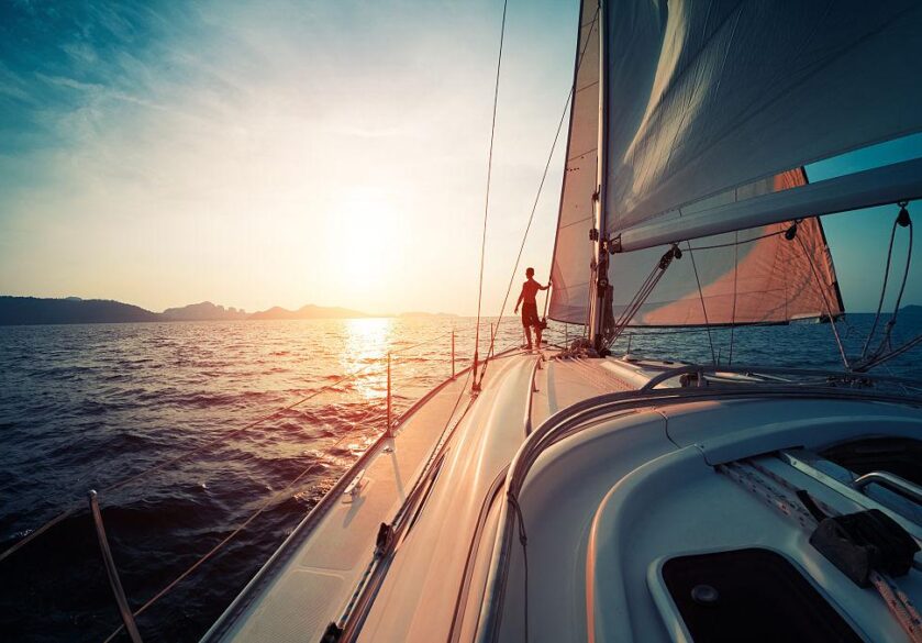 A solo sailor sails into the sunset
