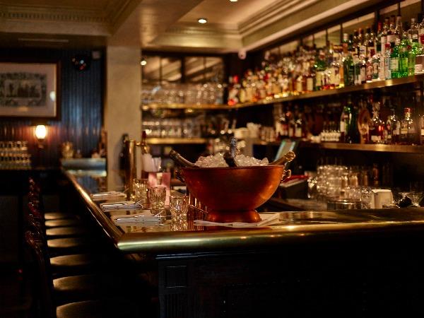 An interior shot of the bar at Gymkhana, with champagne on ice and hundreds of bottles of spirits behind.
