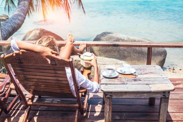Young woman enjoys drinking coffee and coconut. Koh Phangan island, Thailand