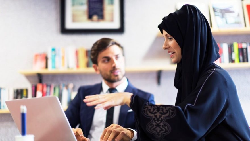 Two people discussing work over a laptop