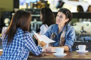 Two people talking over coffee