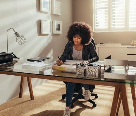 Woman working on new building plans while sitting at her desk.