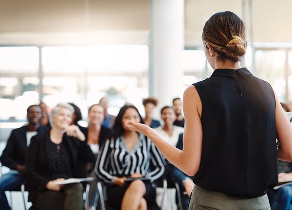 A tutor leads a seminar for a room full of personal assistants.