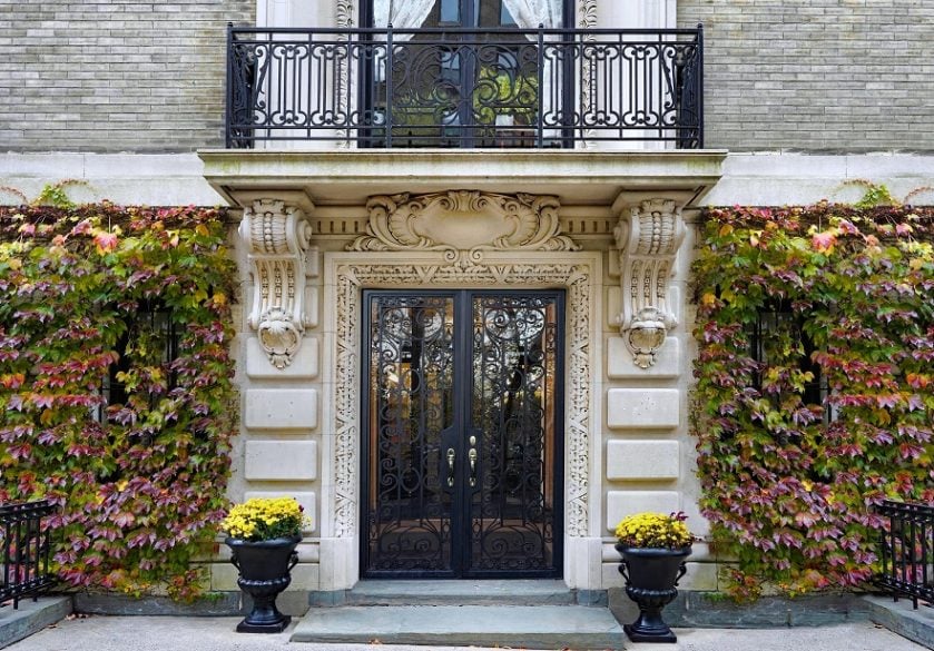 Elegant entrance to apartment building, surrounded by ivy with fall colors