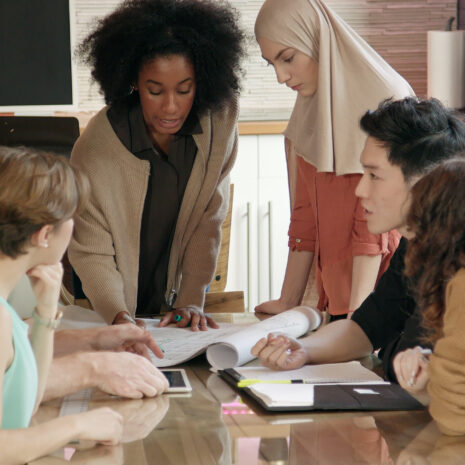 Medium close up of a young woman leading a team meeting.