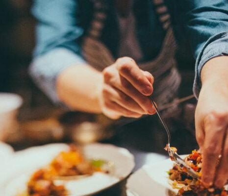 A temporary private chef plates up a rice salad at a large private event where he has been hired by the principal.