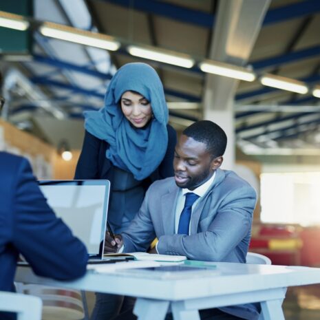 Group of diverse team members huddled around a table in an office