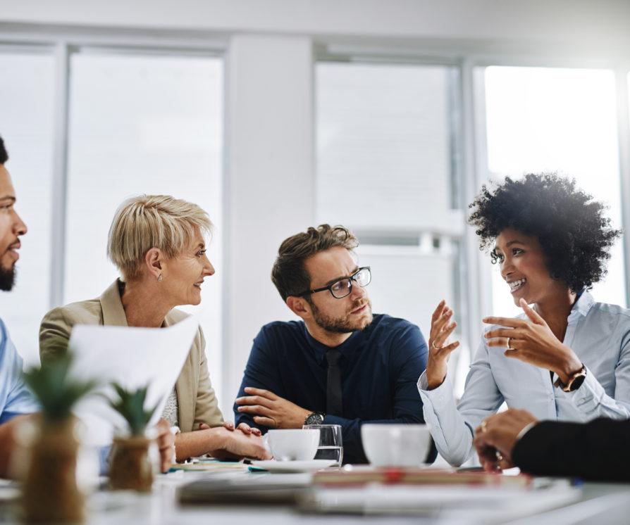 A diverse group of business colleagues sitting around together and discussing core business decisions.