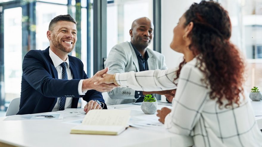 Two businessmen congratulating a successful job interviewee