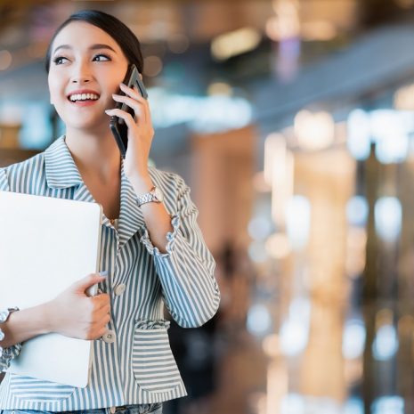 A businesswoman on the phone in a bright, modern office.