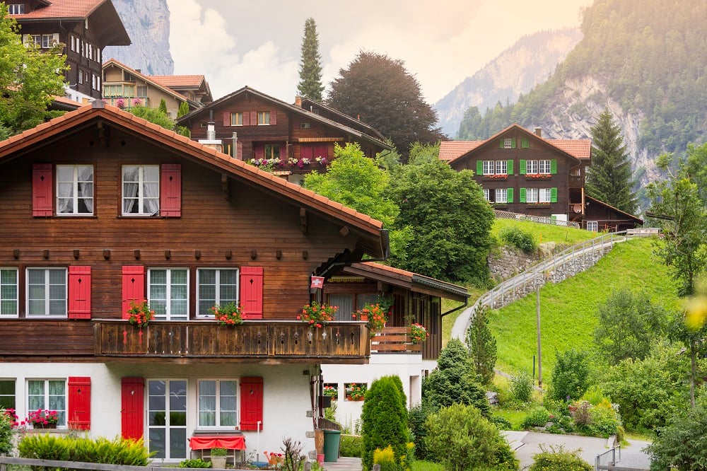 A photo of houses with colourful window shutters situated in the country hills