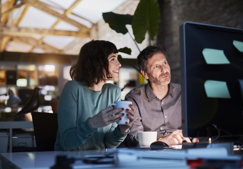 A woman and man working together at a computer.