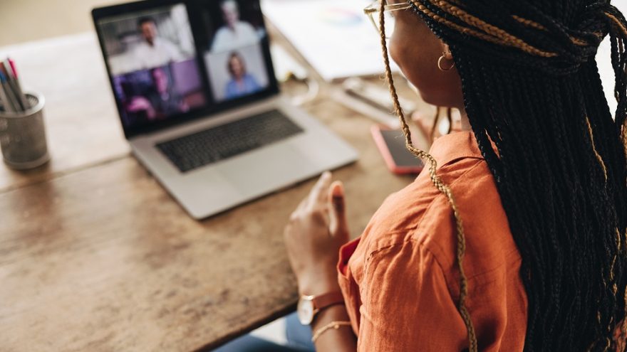 A woman sat at a home office desk on a video call