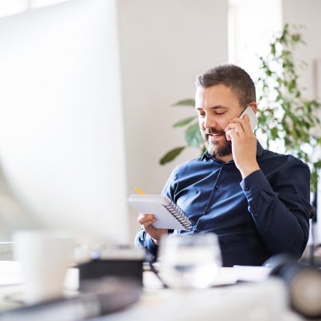 A business assistant on the phone in an office.