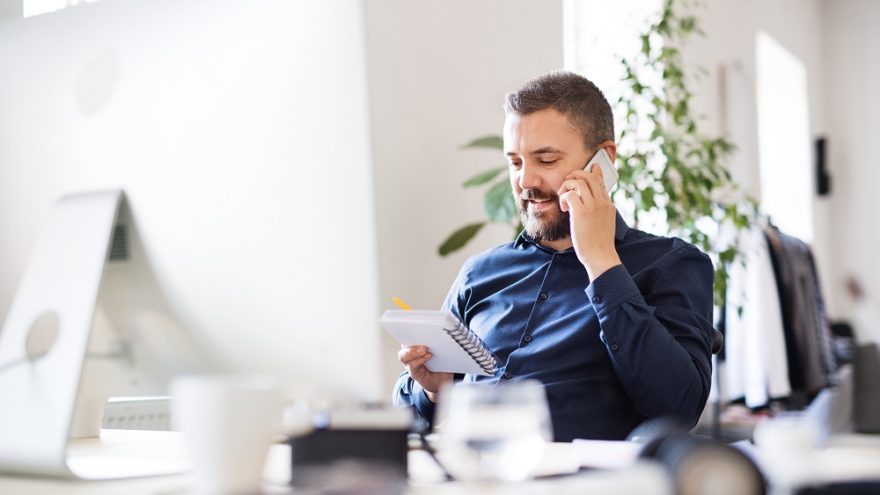 An assistant taking a phone call in a modern office.