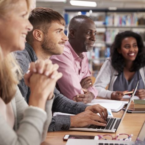Colleagues in a meeting, smiling and engaging with the host