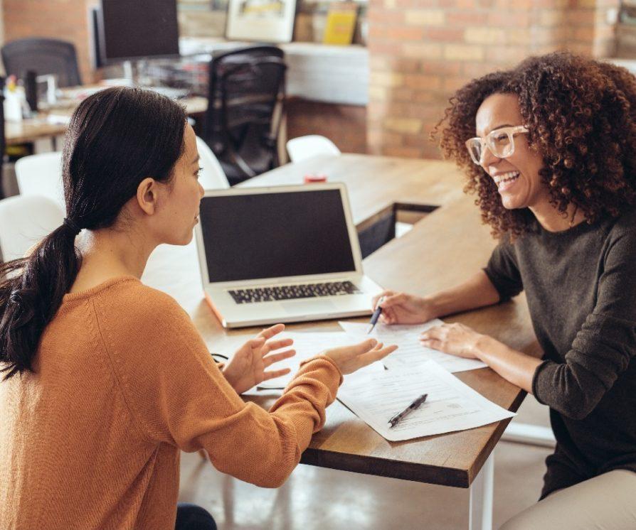 Two women talking sitting at the table.