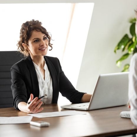 Smiling consultant talking to a client on a business meeting in bright office, portrait.