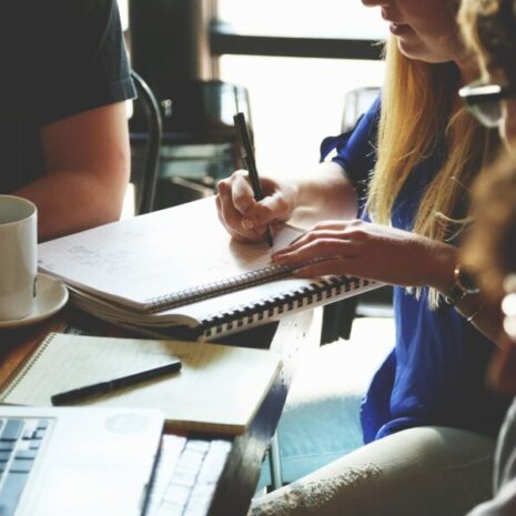 Events managers discussing an event they're planning for their company. They're taking notes and discussing their action.