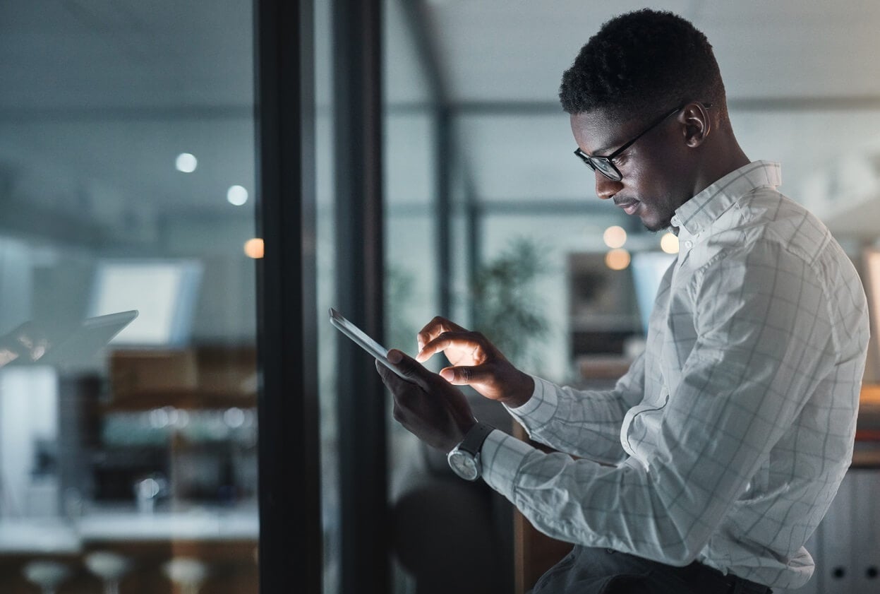 Man standing in office using a tablet