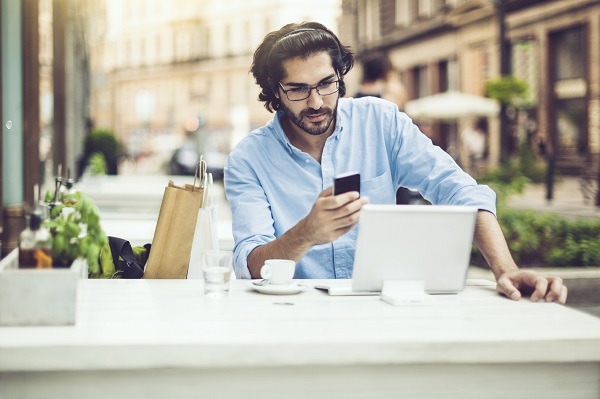 Man looking on his phone while working at a cafe