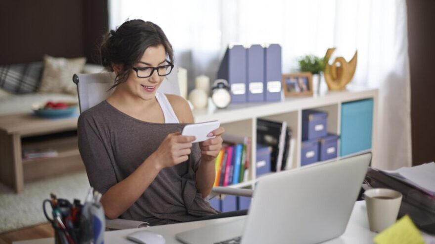 Remote worker sits at her desk at home in front of a laptop
