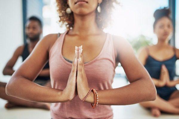 A yoga wellbeing specialist in a yoga pose while leading a class.