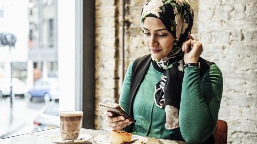 Mid adult woman using smartphone in cafe