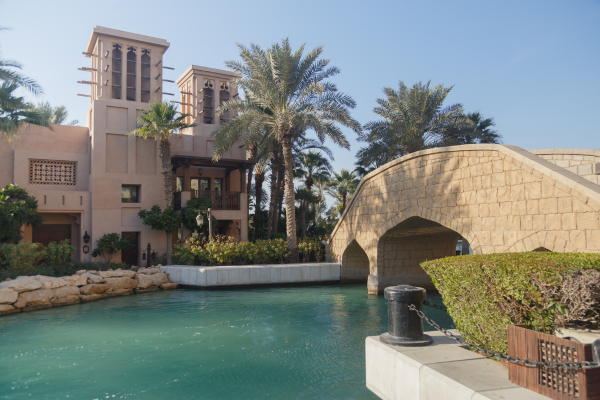 Exterior of a large dubai house with a bridge crossing a moat.
