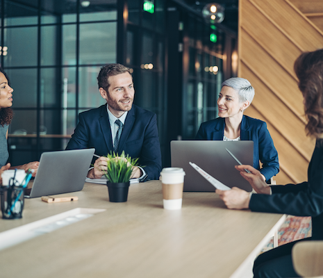 Four people sitting around office meeting table