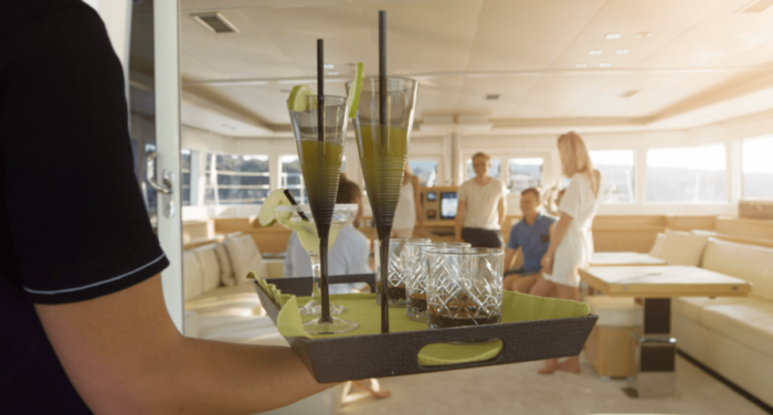 A waiter bringing out drinks to serve to awaiting guests