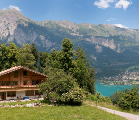 A mountain chalet overlooking a Swiss lake on a sunny day.